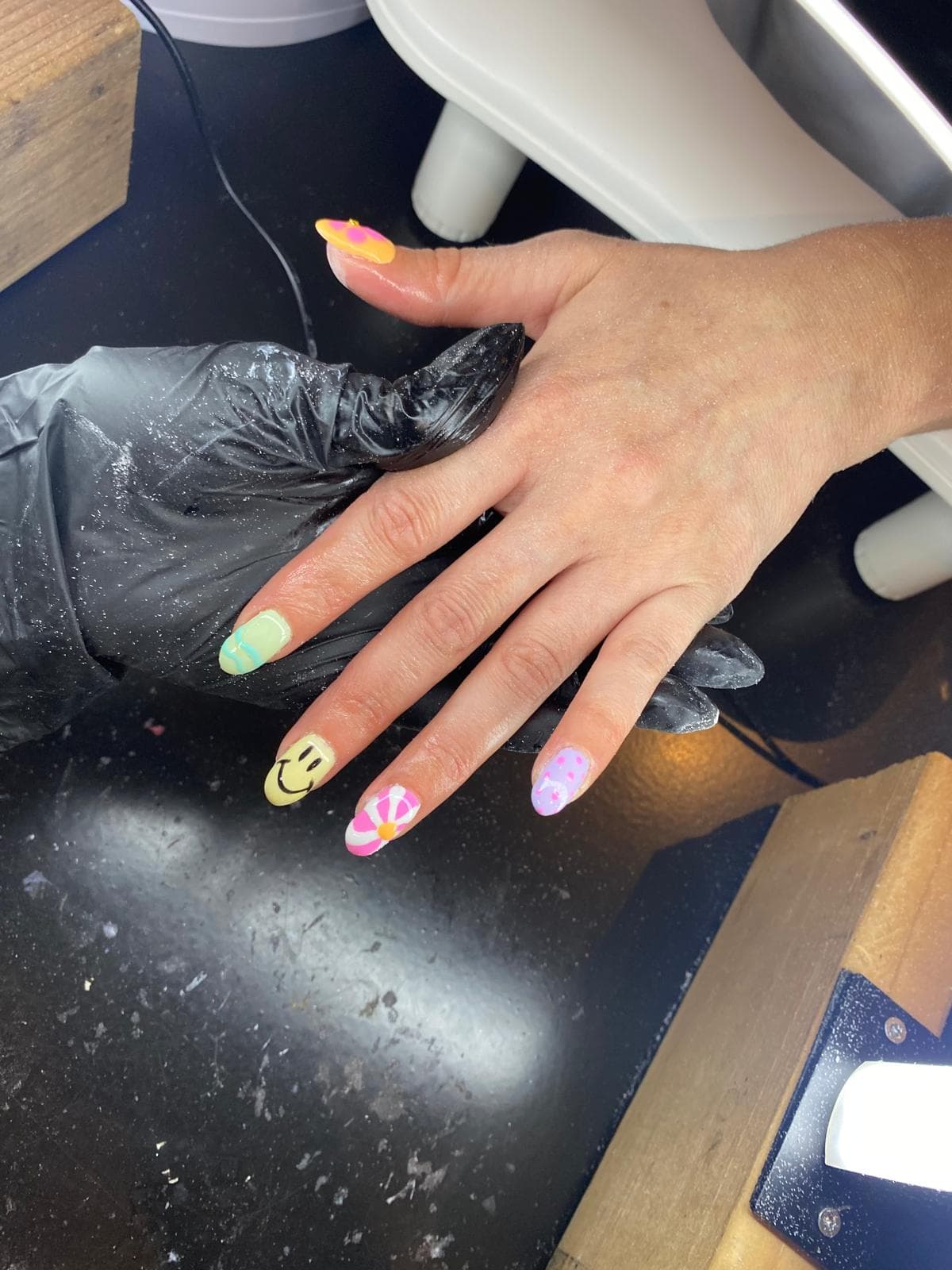 Pastelkleurige nail art met smiley en bloem